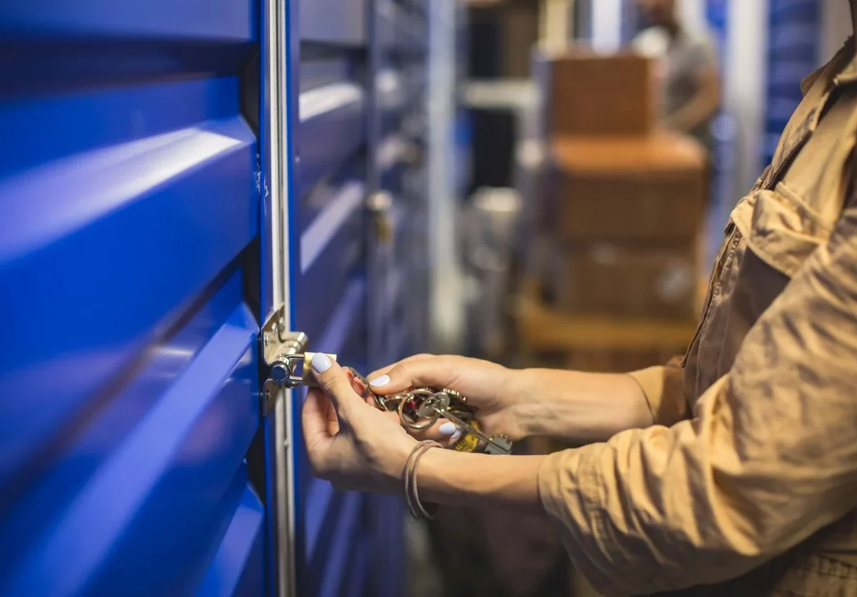 Hands lock the door of a self storage unit.