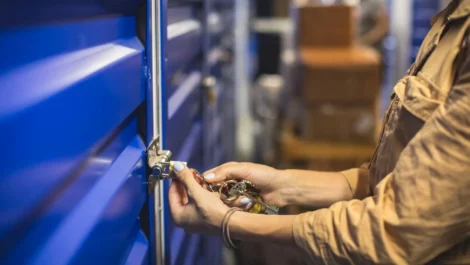 Hands lock the door of a self storage unit.