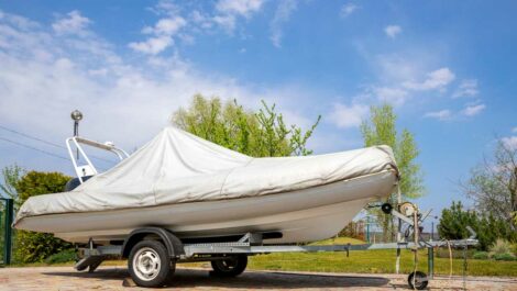 A boat sitting on top of a trailer, covered by a tarp