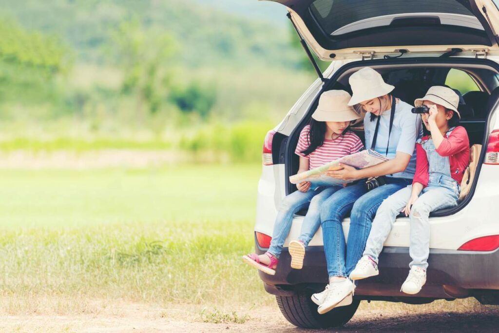 Group family children travel in a car looking at a map for adventure nature in vacations.