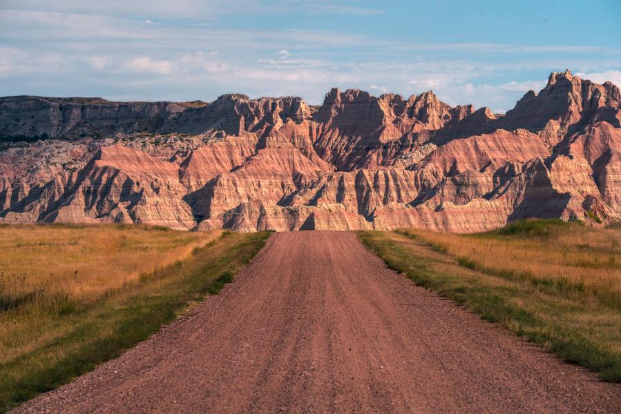 A dirt road leading up to a steep canyon area in Badlands National Park