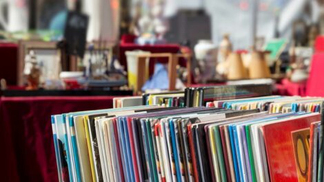 A collection of records on a shelf at a flea market.